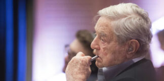 Elderly man pensively listening during an event.
