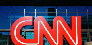 Large red CNN logo outside a building.