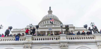 People gathering outside the Capitol building with flags.