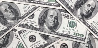 A pile of hundred dollar bills featuring Benjamin Franklin