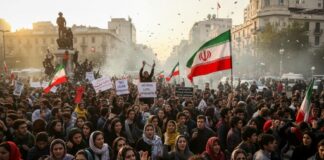 Large crowd of protesters holding Iranian flags and signs during a demonstration