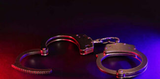 Handcuffs illuminated by red and blue lights.