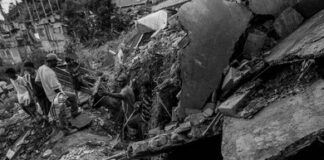 Rescue workers survey collapsed building debris