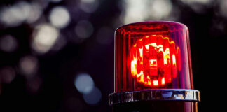 Red police siren light against blurred background.