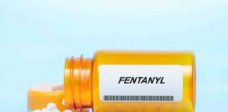 Orange pill bottle labeled Fentanyl with white pills.
