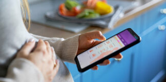 Pregnant woman checking a pregnancy app on a smartphone