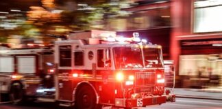 A fire truck with flashing lights responding to an emergency in a city at night