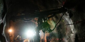 Worker operating machinery in a dimly lit tunnel