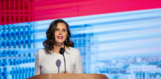 Woman speaking at a podium against colorful background