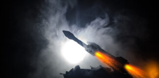Silhouette of a military vehicle launching a rocket amidst smoke and dramatic lighting