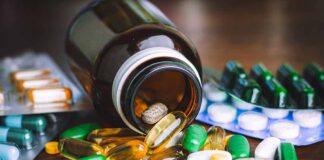 Assorted pills and capsules spilling from a brown bottle