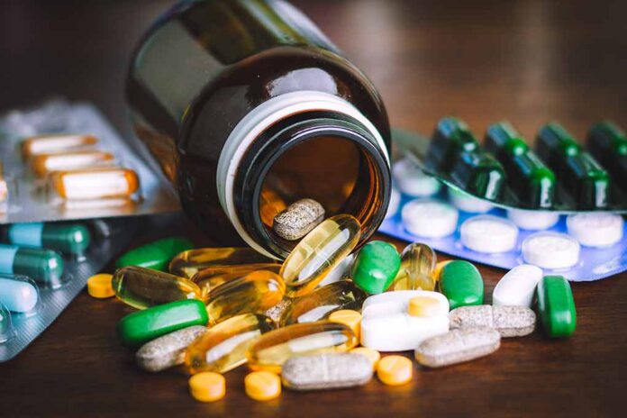 Assorted pills and capsules spilling from a brown bottle