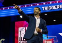 Live Death Threats Rock Trump Jr. A man giving a speech at a conference, gesturing emphatically