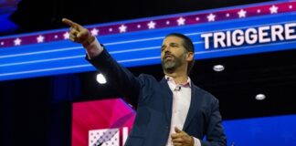 A man giving a speech at a conference, gesturing emphatically