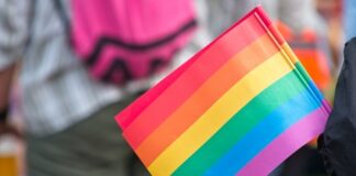 Close-up of a rainbow pride flag held by a person