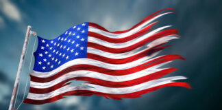 Tattered American flag waving in the wind.