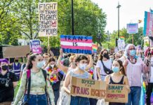 Group protesting for trans rights with various signs.