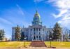 State capitol building with golden dome under blue sky.