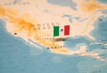 Mexican flag pin on a map of Mexico.