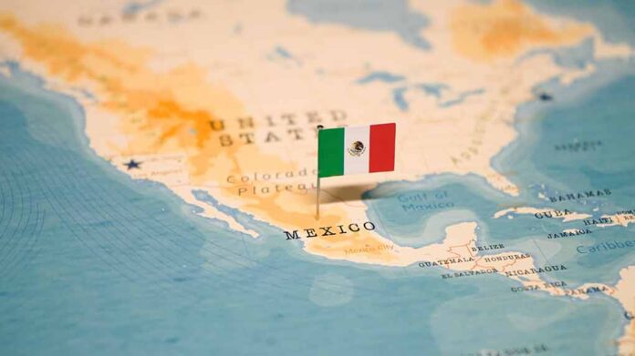 Mexican flag pin on a map of Mexico.