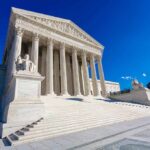 Supreme Court building with columns and statues.