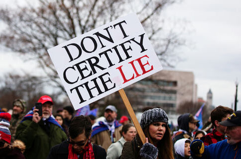 Protester holding a large sign at a political rally