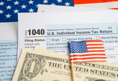 U.S. tax forms with a small American flag and dollar bills
