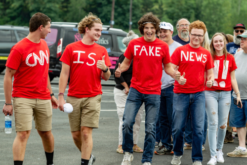 Group wearing CNN is Fake News shirts thumbs up