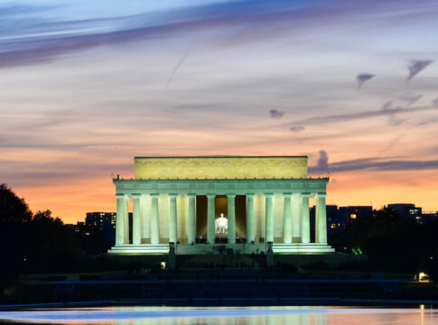 Lincoln Memorial illuminated at sunset with reflection in water