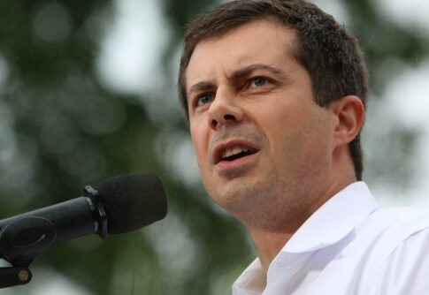 Individual speaking passionately into a microphone at an outdoor event