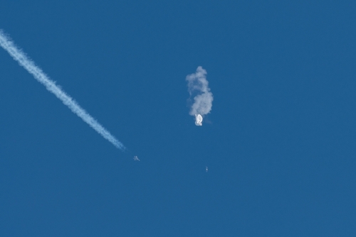 Aircraft intercepting an airborne object releasing smoke.