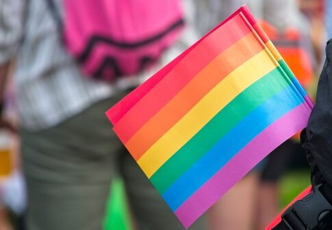 Close-up of a rainbow pride flag held by a person