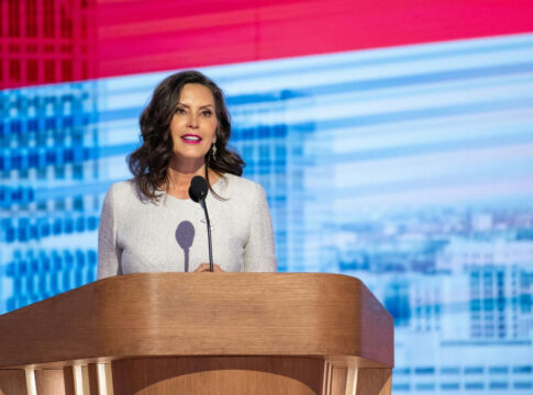 Woman speaking at a podium against colorful background