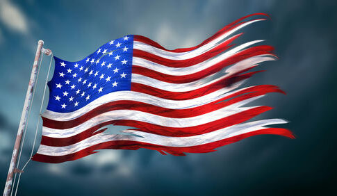Tattered American flag waving in the wind.