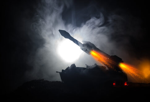 Silhouette of a military vehicle launching a rocket amidst smoke and dramatic lighting